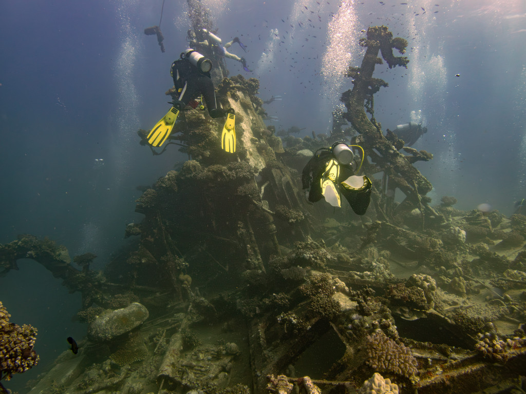 two divers in front of a wreck